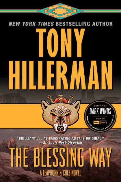 Book cover for The Blessing Way by Tony Hillerman, featuring bold yellow text, an illustrated wolf mask, a Southwestern pattern at the top, and a sticker promoting the AMC series Dark Winds.